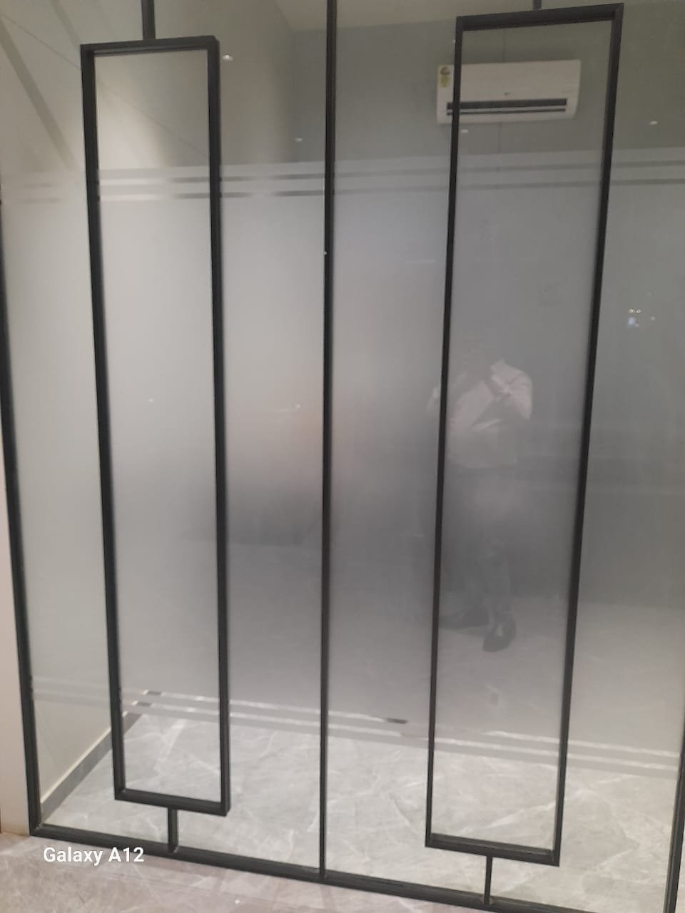 Black frame glass partition with frosted panels