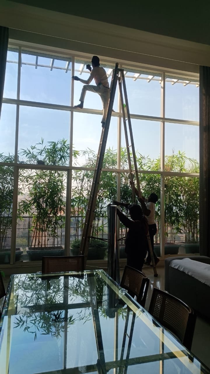 Team installing film on large residential glass wall