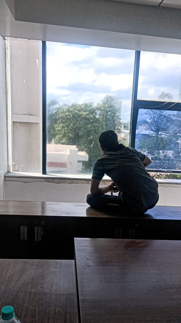 Worker applying blue film on office window